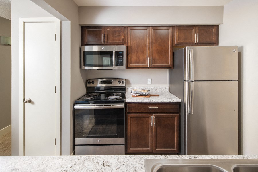 an updated kitchen with stainless steel appliances and granite counter tops