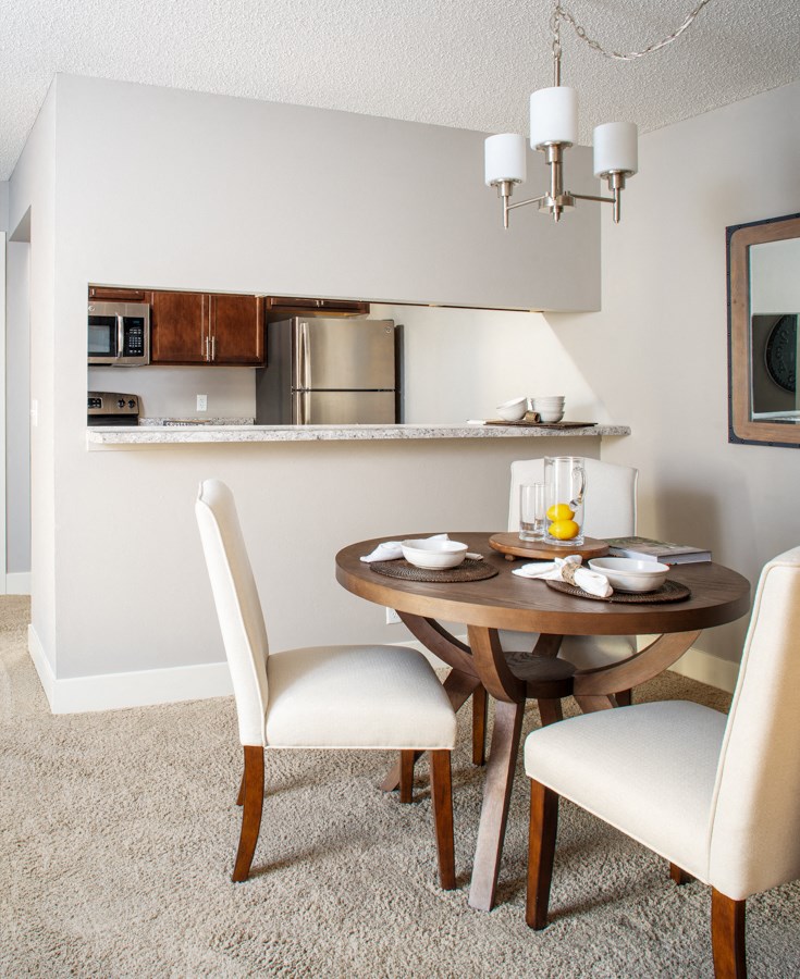a dining room with a table and chairs and a kitchen