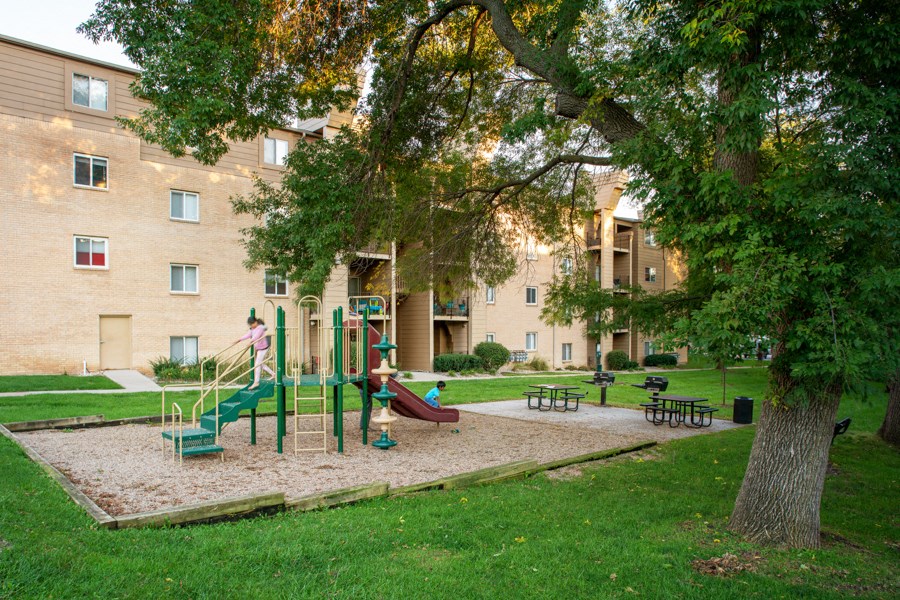 a playground in a park in front of a building