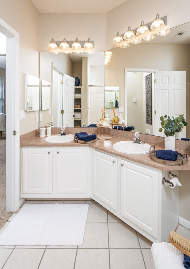 a white bathroom with two sinks and a mirror