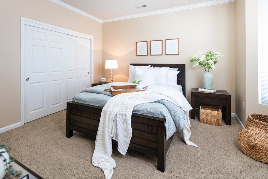 a bedroom with a bed and a dresser and a door