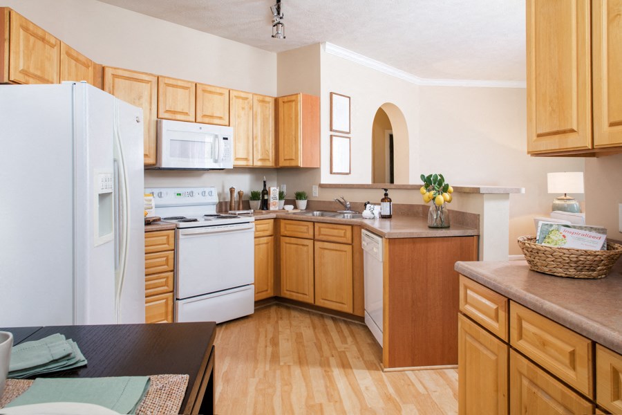 a kitchen with white appliances and wooden cabinets