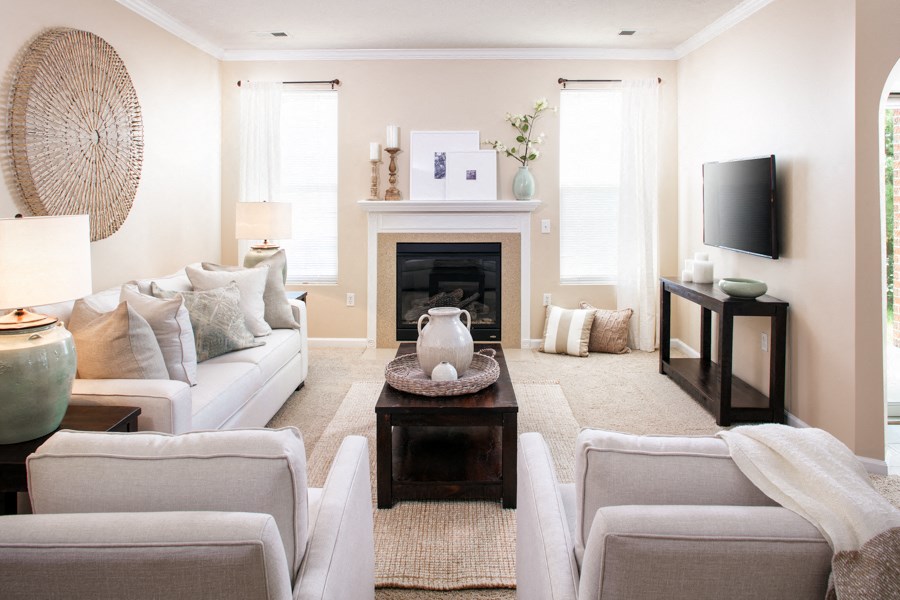 a living room with white furniture and a fireplace