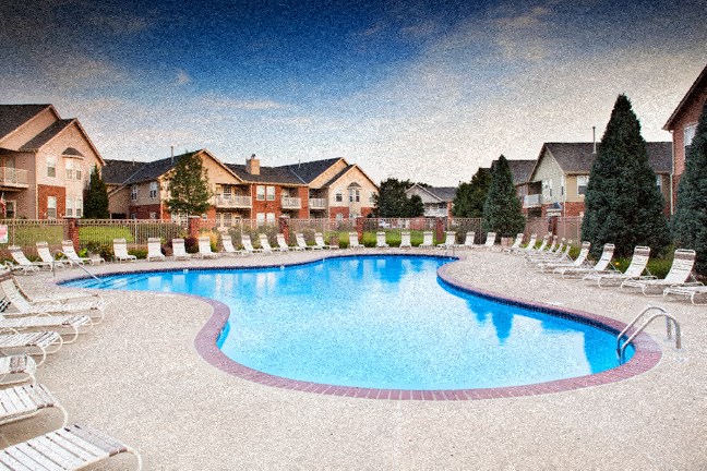 an empty pool with chairs and houses in the background