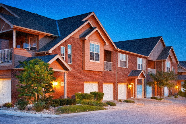 a house with lights on in a neighborhood at night