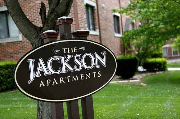 a sign in front of a building that says the jackson apartments