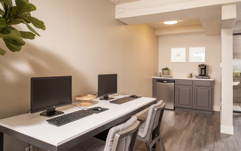a home office with two computers and a keyboard on a desk