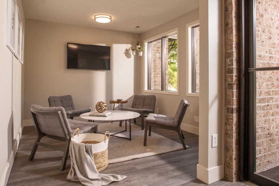 a living room with chairs and a table and a television