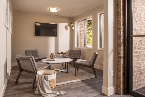 a living room with chairs and a table and a television