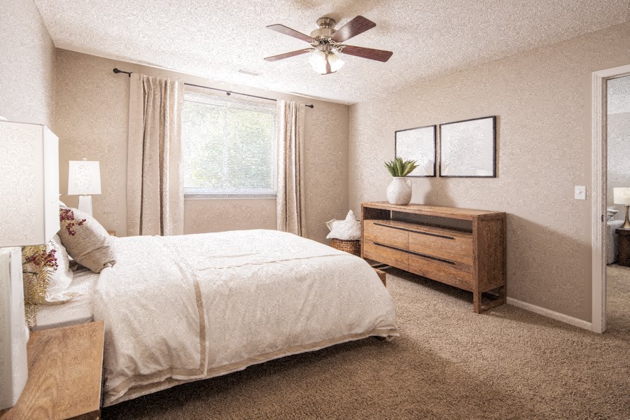 a bedroom with a bed and a ceiling fan