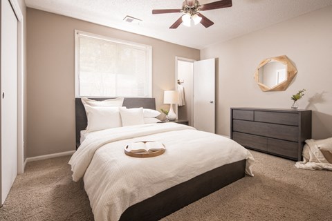 a bedroom with a large bed and a ceiling fan