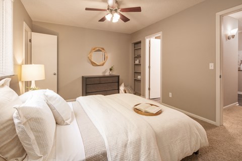 a bedroom with a large bed and a ceiling fan