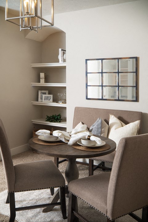 A dining room with a round table and chairs.