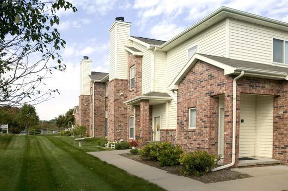 a row of houses with brick and white siding