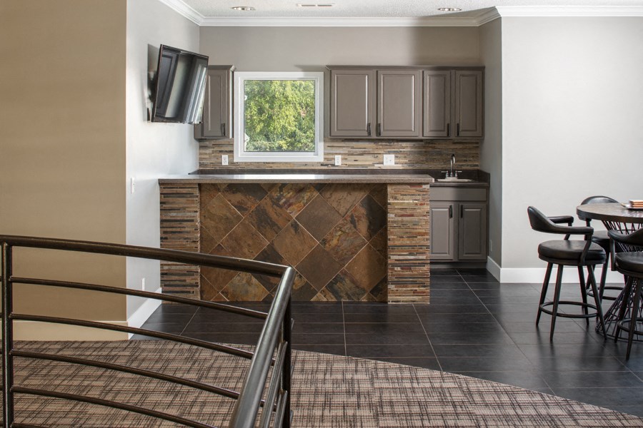 a view of a kitchen with a bar and a table with chairs