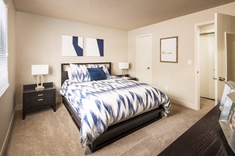 a bedroom with a bed and a door to a closet