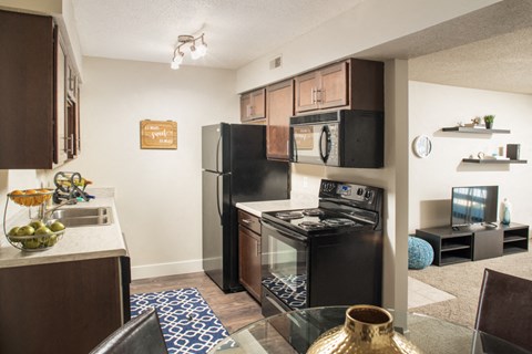an open kitchen and living room with a black refrigerator and stove