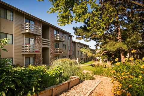 an exterior view of an apartment building with a garden