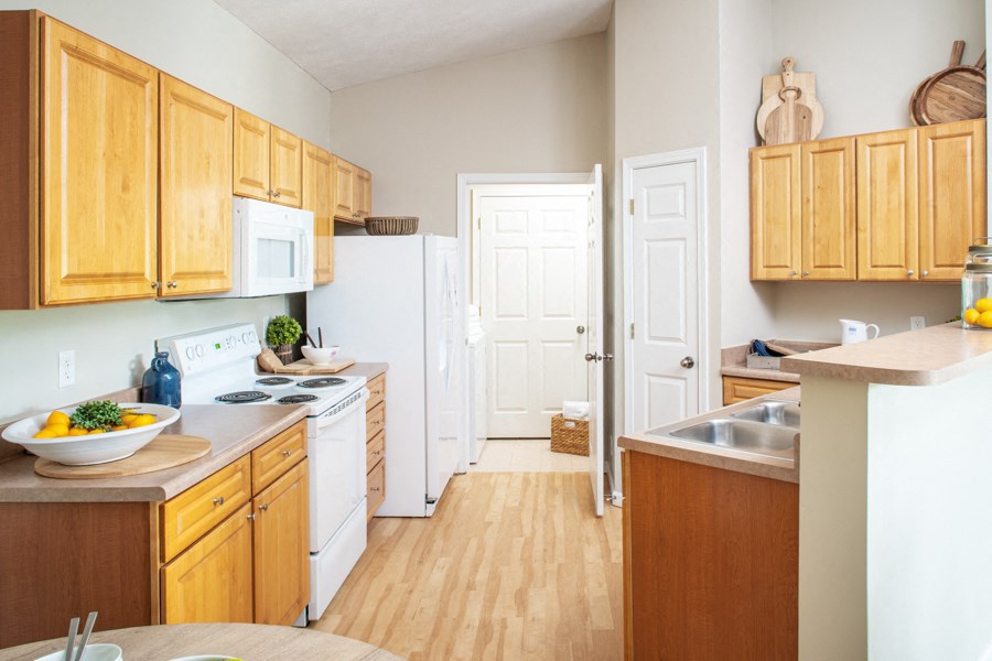 a kitchen with wooden cabinets and white appliances and a door