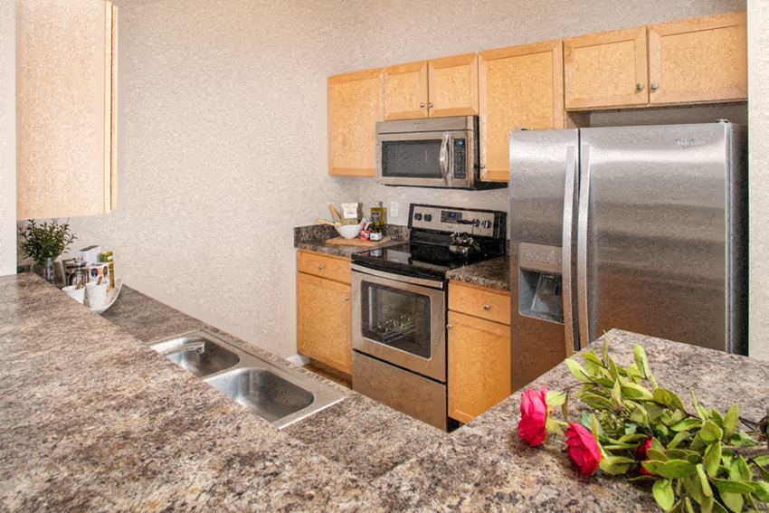 a kitchen with granite countertops and stainless steel appliances