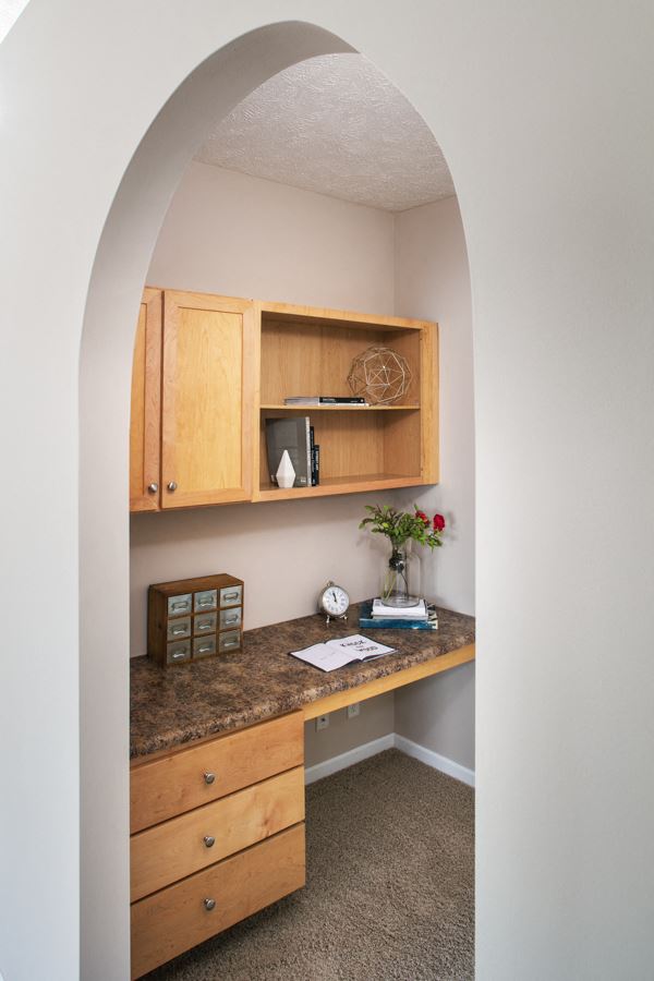 a home office with a desk and cabinets