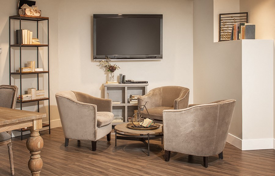 a living room with chairs and a television on the wall
