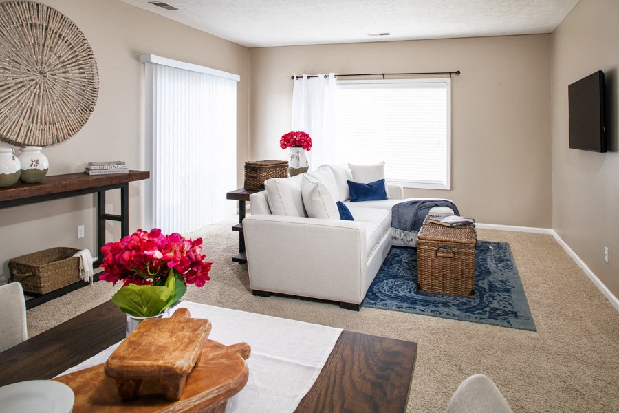 a living room with a white couch and a rug and a television