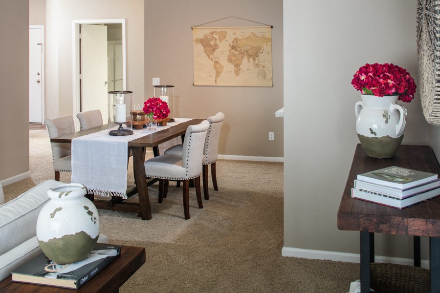 a dining room with a table and chairs and a vase with flowers