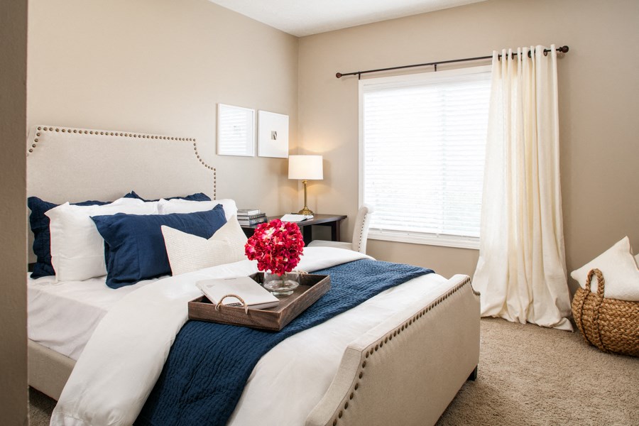 a bedroom with a bed and a tray with flowers on it