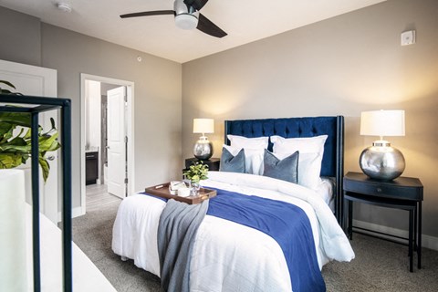A bedroom with a large bed and a ceiling fan.