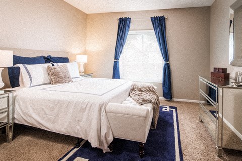 a bedroom with a bed and a window with blue curtains