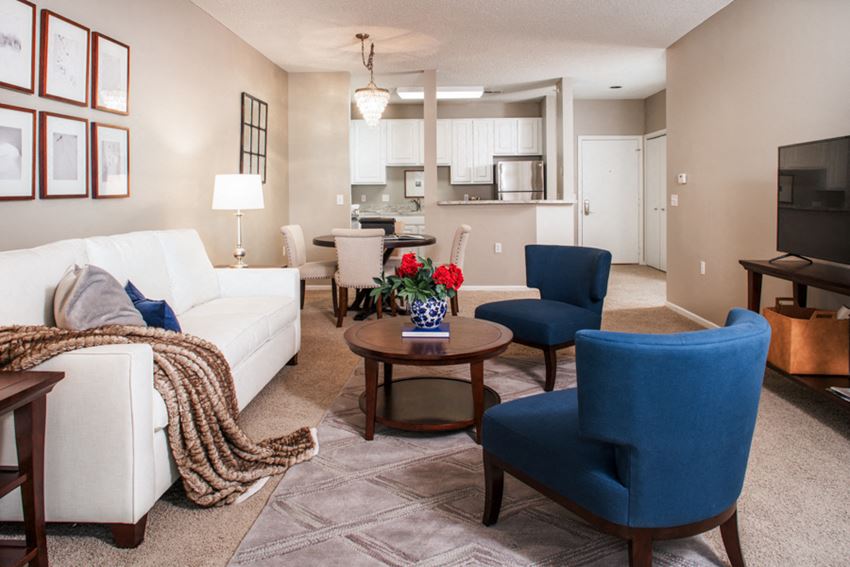 a living room with a white couch and blue chairs