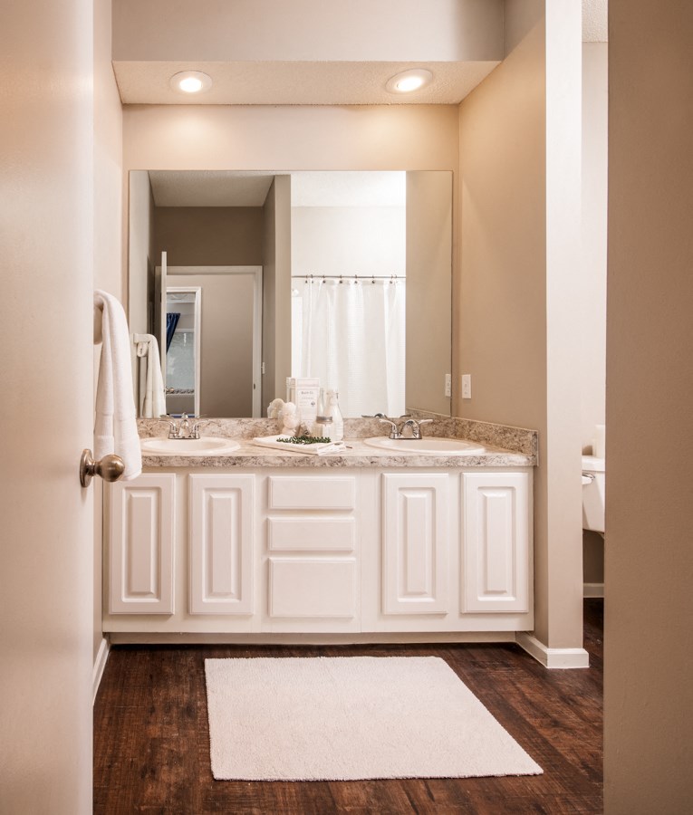 a bathroom with white cabinets and a sink and a mirror