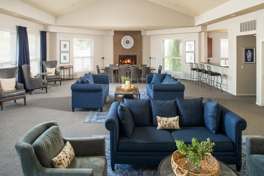 a large living room with blue couches and chairs and a fireplace