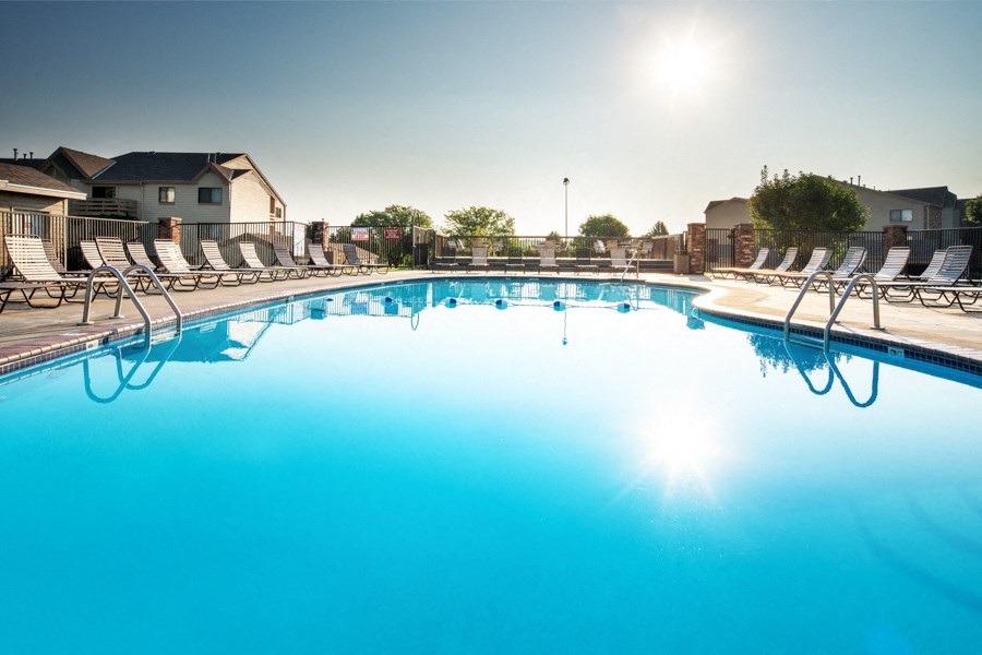 a large swimming pool with lounge chairs around it