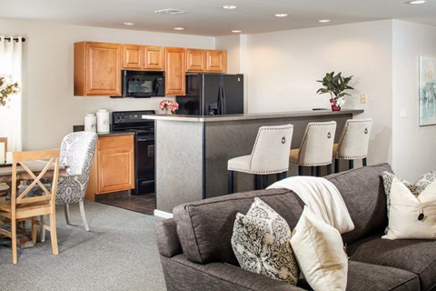 a living room and kitchen with a couch and a table