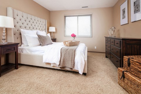 a bedroom with a bed and a dresser and a window