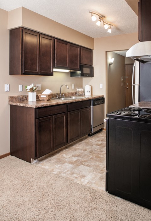 a kitchen with dark wood cabinets and a stove and a refrigerator
