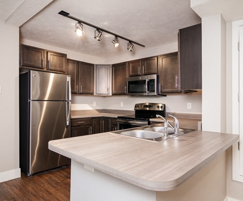 a kitchen with stainless steel appliances and wooden cabinets
