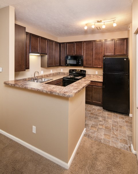a kitchen with black appliances and granite counter tops