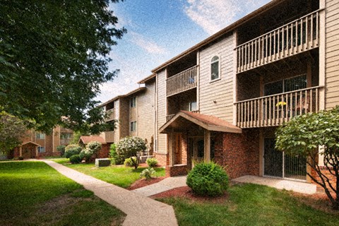 an exterior view of an apartment building with a sidewalk and grass