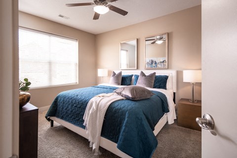 a bedroom with a bed and a ceiling fan