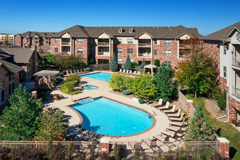 an aerial view of a swimming pool with apartments in the background