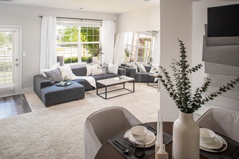 a living room with couches and chairs and a table with a vase