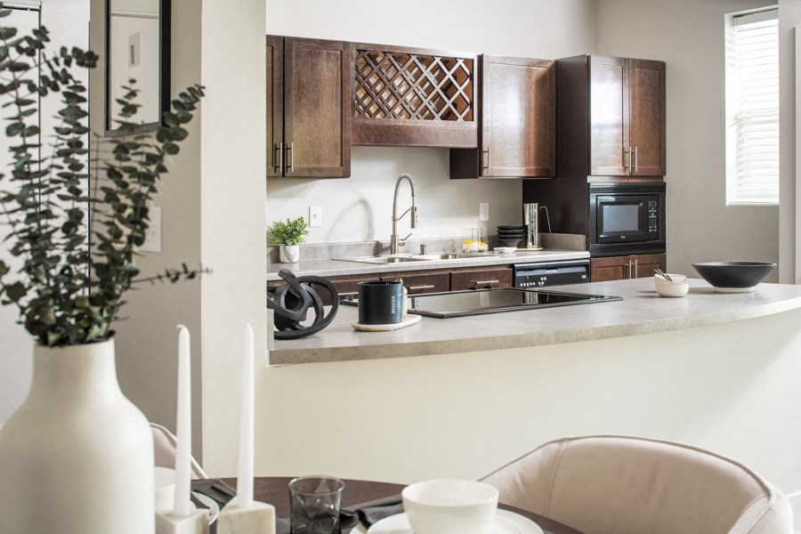 a kitchen with wooden cabinets and a table with a vase