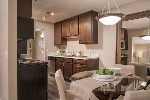 A modern kitchen with a dining table set for two.