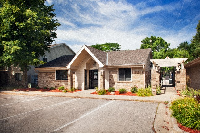 the front of a brick house with a driveway