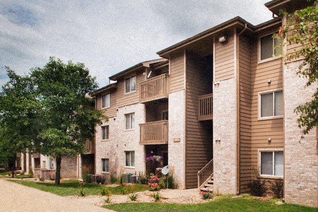 a row of brick apartment buildings with balconies and a tree