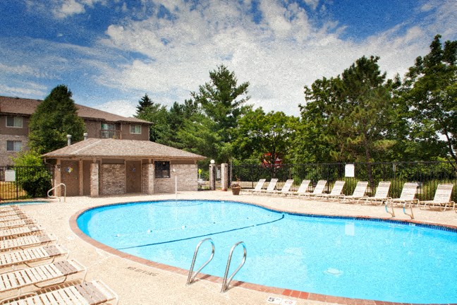 a swimming pool with chairs in front of a house
