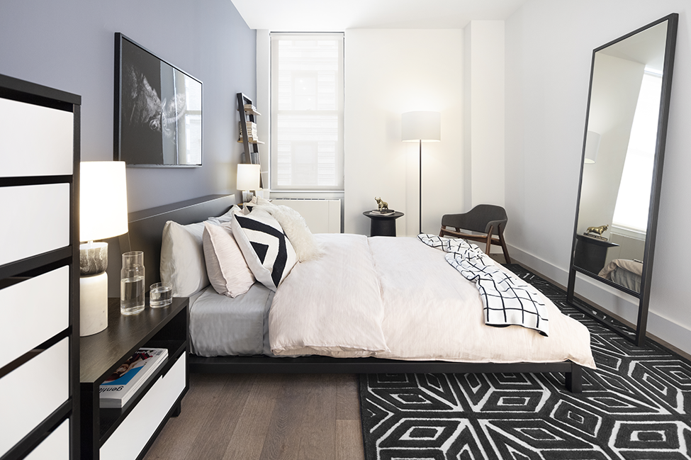 a bedroom with a large bed and a black and white rug